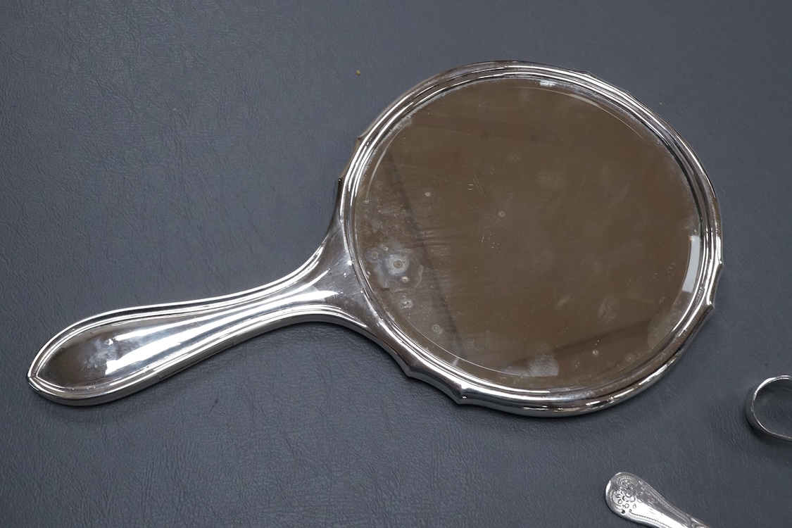 A George V silver mounted hand mirror, a silver spoons and pusher, a silver christening fork and spoon and a silver plated tea caddy.